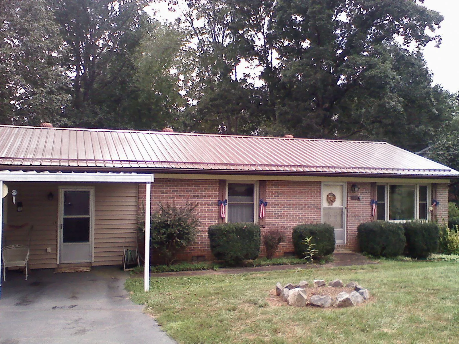Bronze metal roof and carport on a brick ranch home — Roof Repair work by our crew in Locust Dale